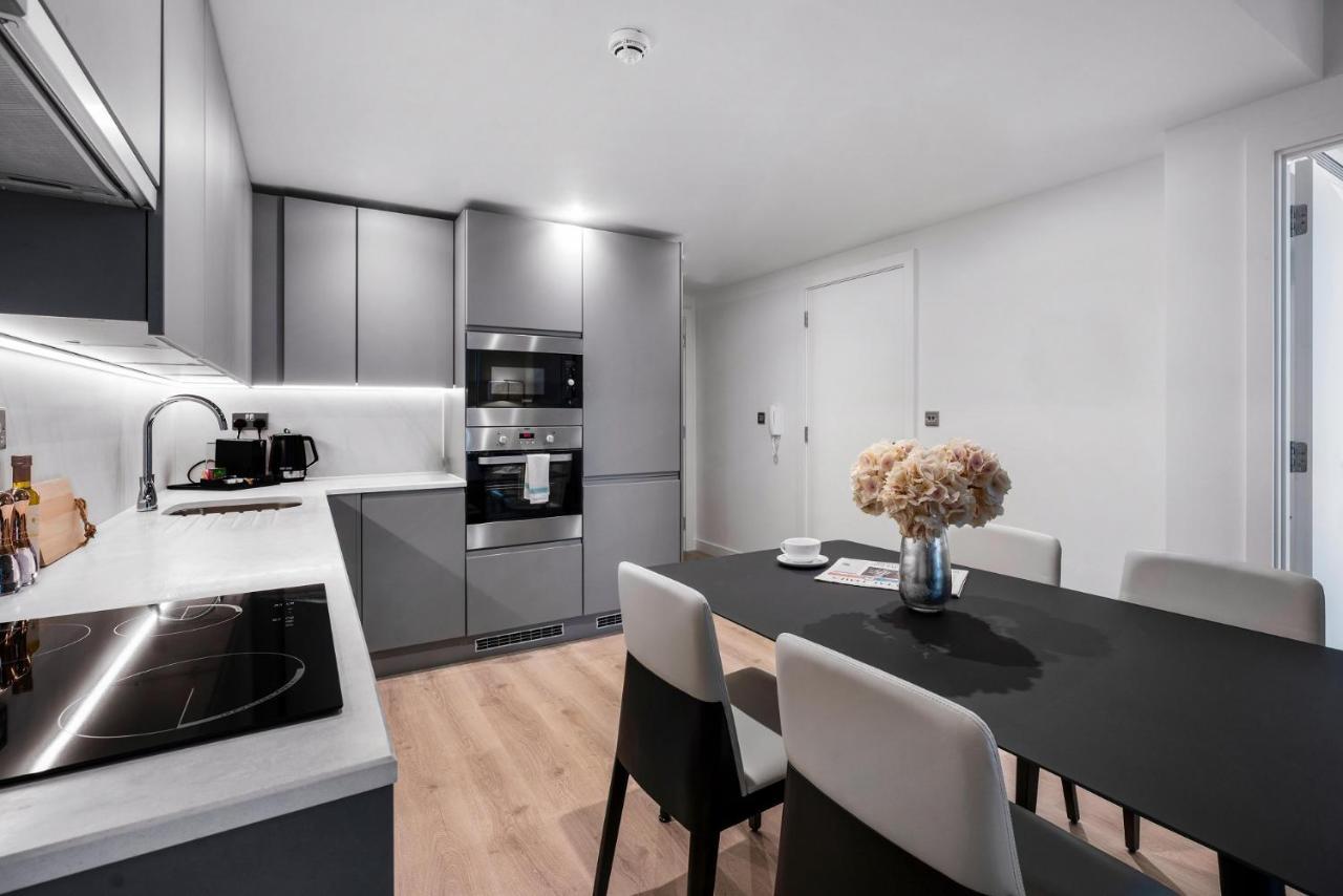 Citysuites 2 Aparthotel マンチェスター エクステリア 写真 The photo shows a modern kitchen and dining area. The kitchen features sleek gray cabinets, a countertop with an embedded cooktop, and built-in appliances, including an oven and microwave. There’s a small coffee maker on the counter. Adjacent to the 