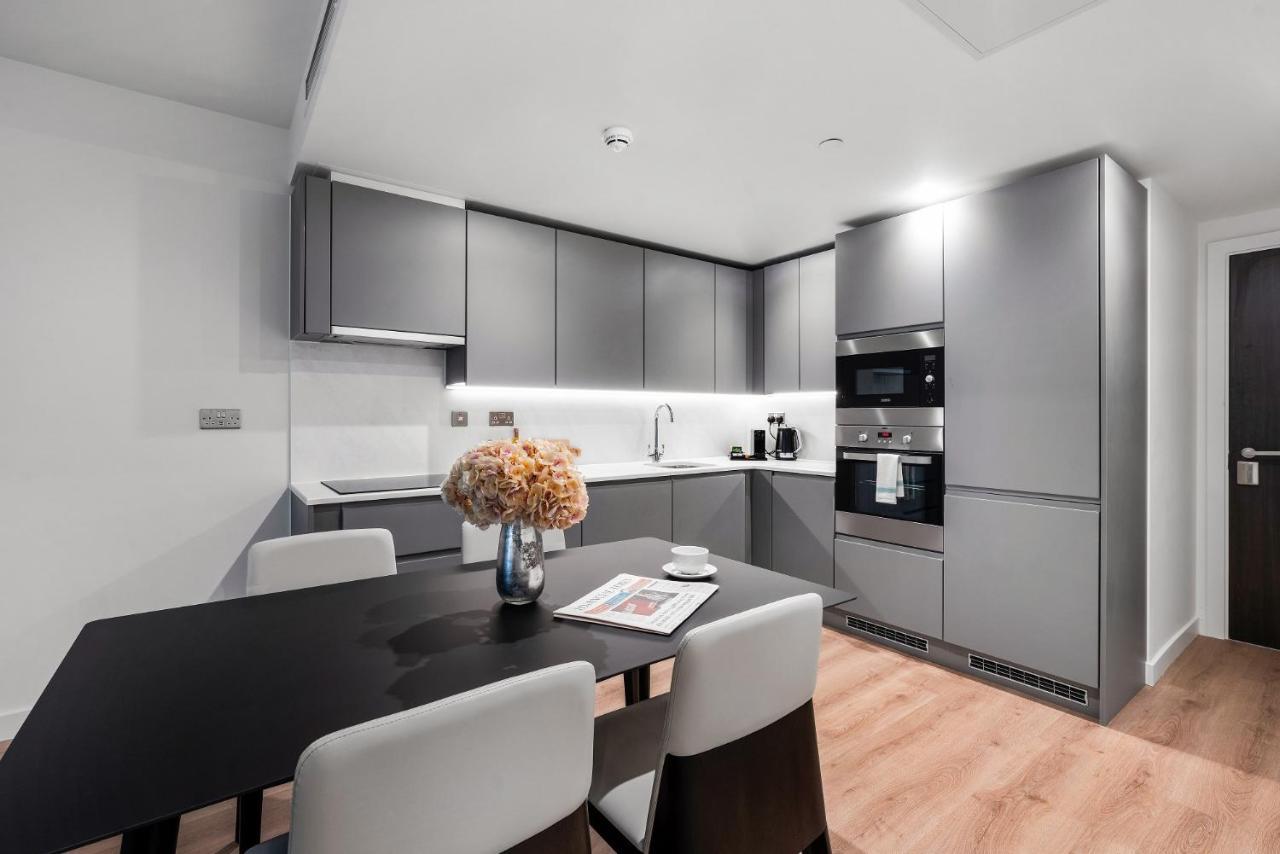 Citysuites 2 Aparthotel マンチェスター エクステリア 写真 The photo shows a modern kitchen space. It features sleek, gray cabinetry with a minimalist design. There is a countertop with a sink, and appliances including an oven and a coffee maker. A dining table is positioned near the kitchen area, accompanie