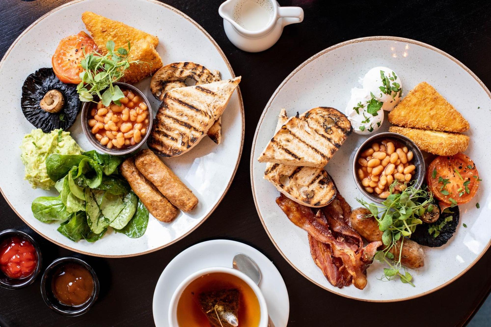 Citysuites 2 Aparthotel マンチェスター エクステリア 写真 The photo displays two plates of hearty breakfast items. Each plate includes:

- Grilled bread slices
- Grilled sausages
- Baked beans served in a small bowl
- Fresh salad with greens
- A slice of tomato
- A piece of grilled mushroom
- Crispy bacon s